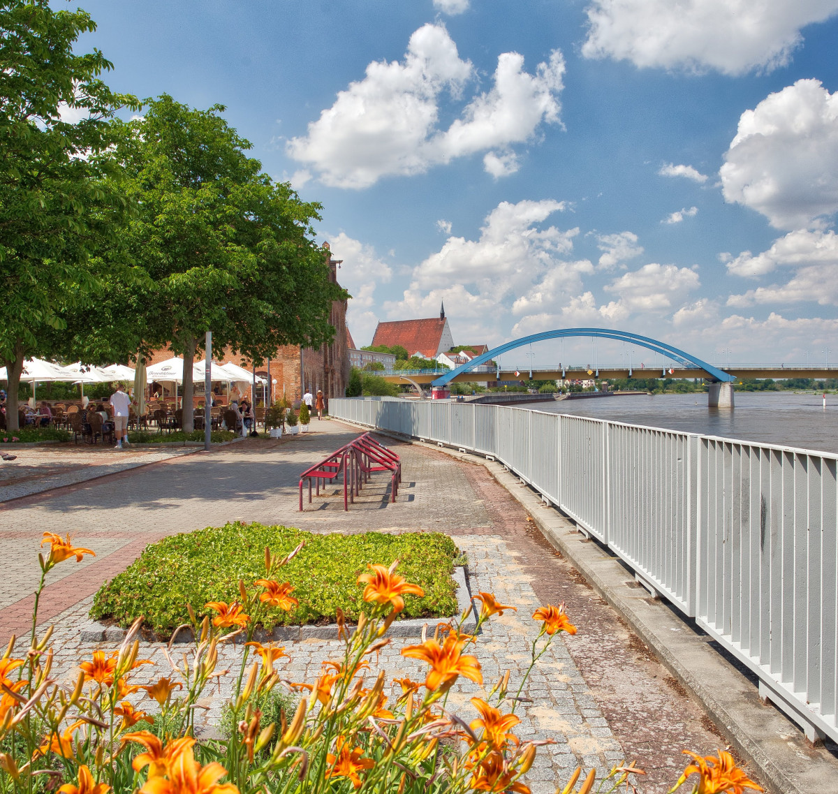 Blick auf die Oderpromenade und Stadtbrücke im Hintergrund. Links ist auch ein griechisches Restaurant mit Biergarten zu sehen.