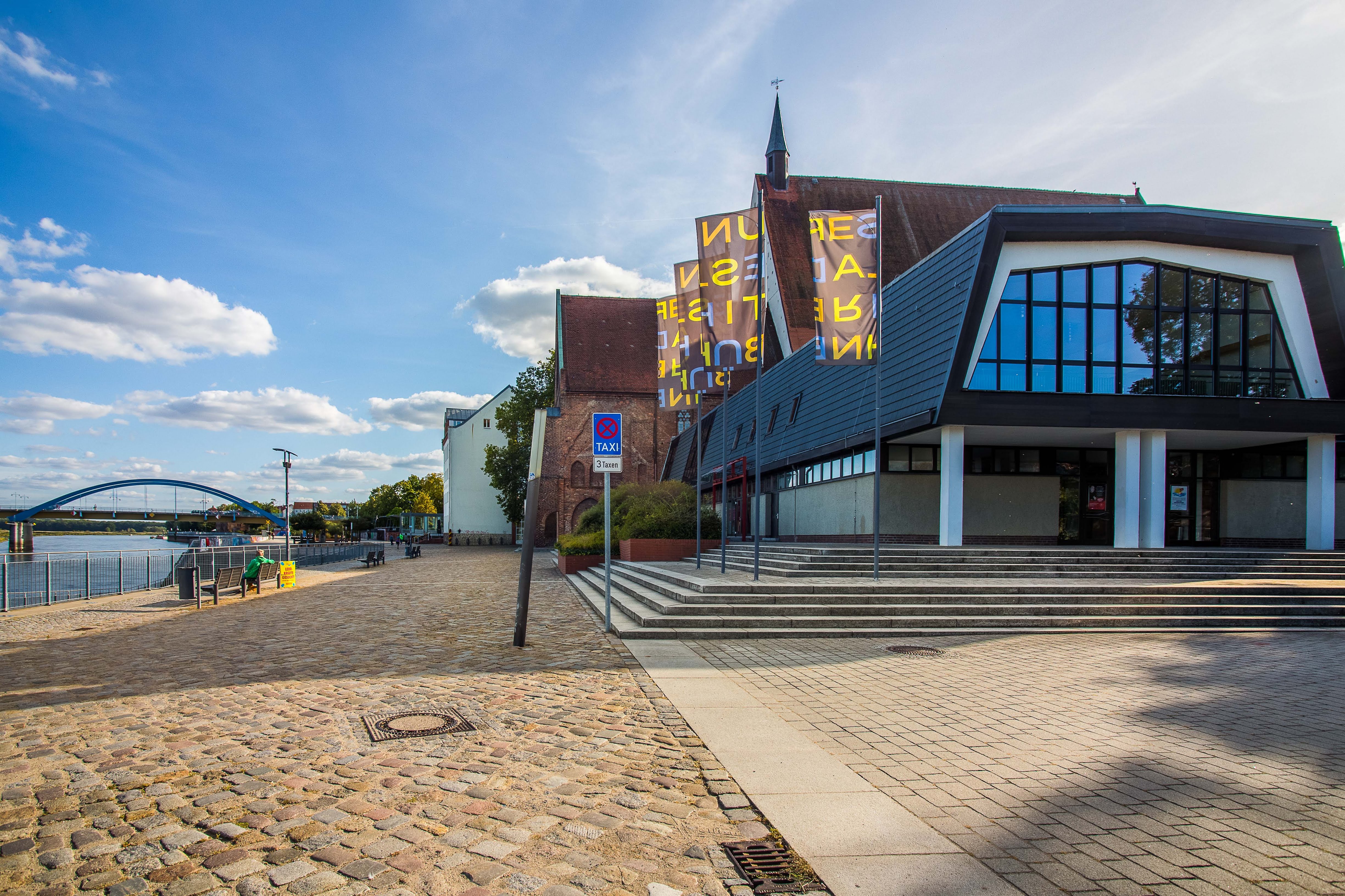 Konzerthalle von draußen fotografiert, im Hintergrund Stadtbrücke
