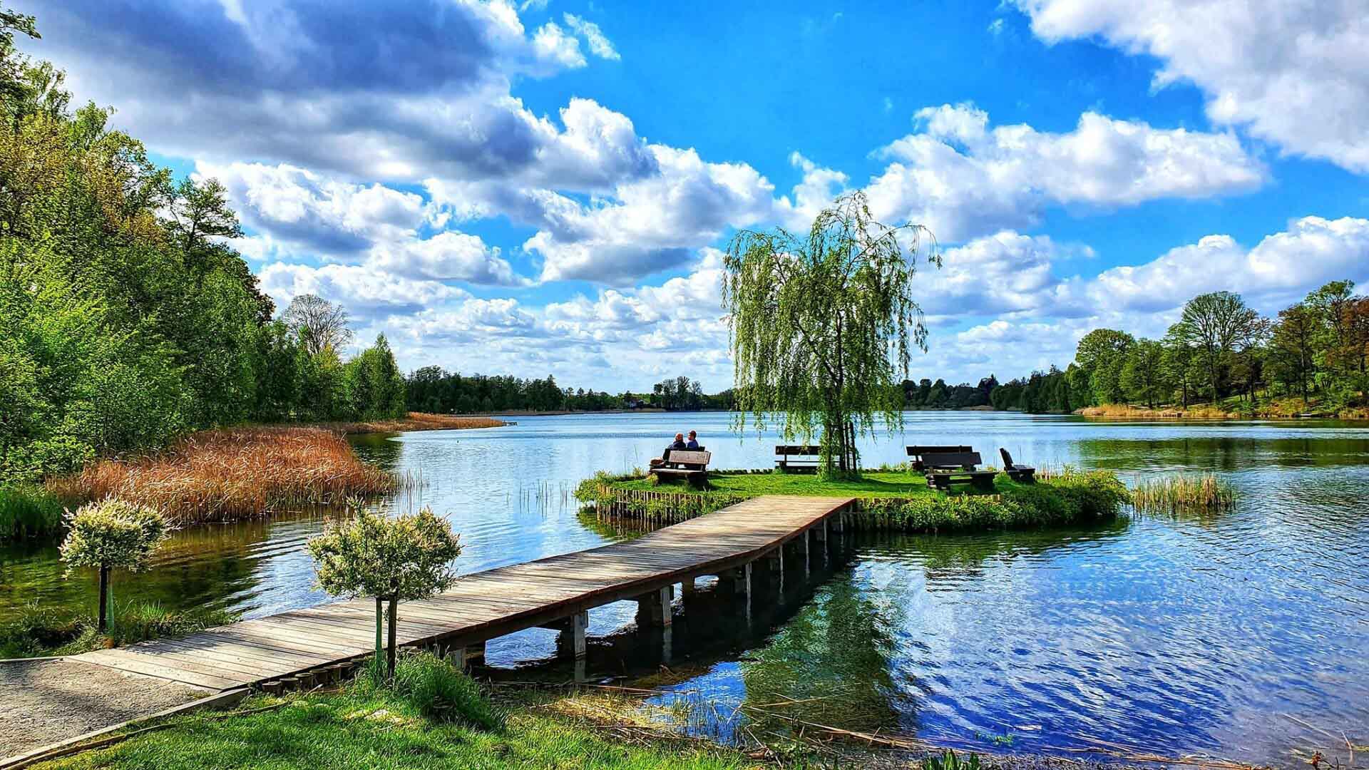 Ein See mit einer kleinen Insel mit vielen Bänken zum Verweilen